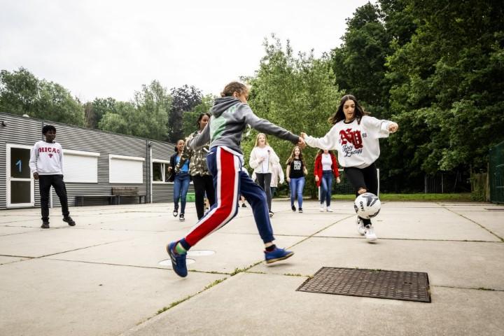 Meisjes voetballen op de speelplaats van Leerexpert Schotensesteenweg 256.